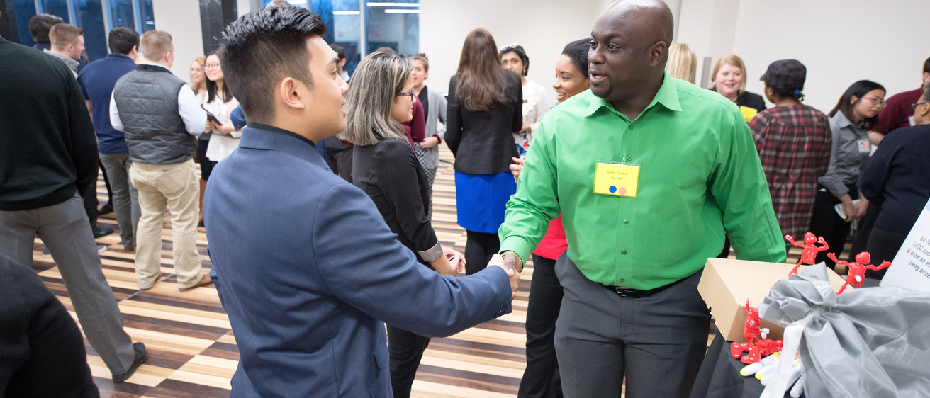 student shaking future employers hand at networking event