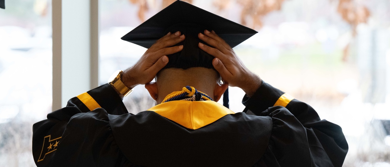 Student adjusting graduation cap