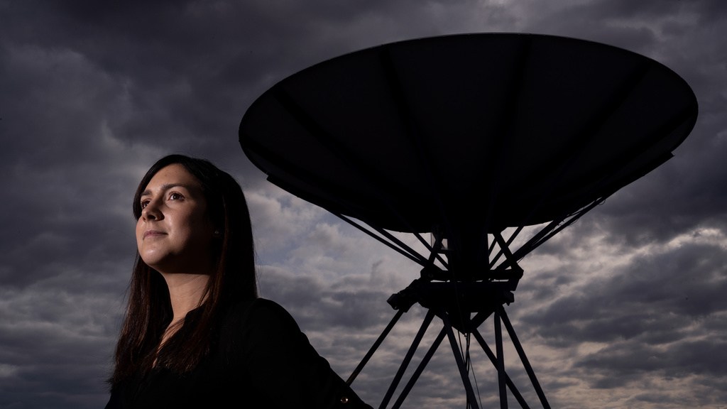 UI Grad Emily Silich looks to the sky while standing in front of a massive satellite dish